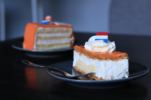 Two orange cakes/ pie slices. Tompouce and chipolata