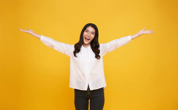 Happy young Asian teenage girl  isolated on yellow background. stock photo