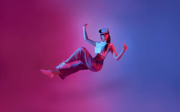 istock Amazed young woman using a virtual reality headset playing video games trying to touch something with hand floating in mid-air. 1399864438