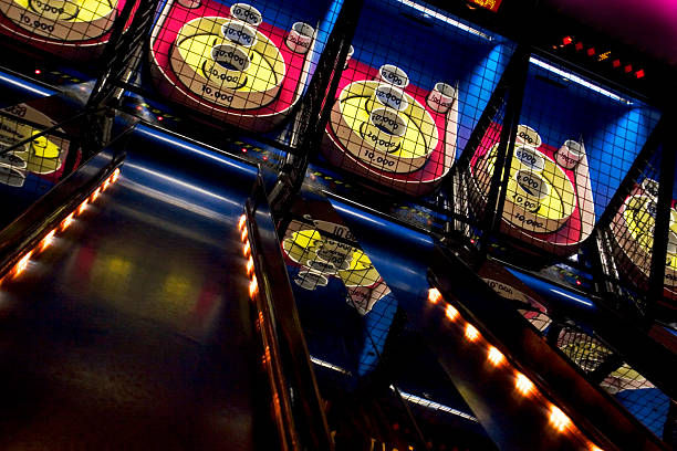Skee ball A series of skee-ball games lined up in an arcade.  Try to roll 100,000. amusement arcade stock pictures, royalty-free photos & images