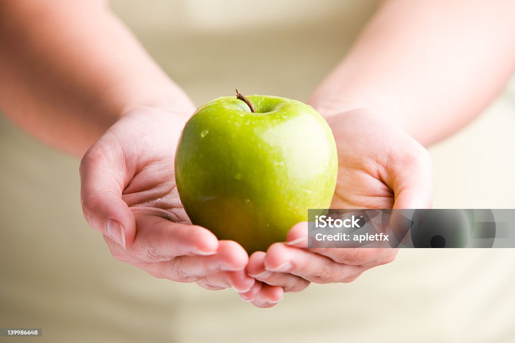 Two hands holding a green apple Woman holding fresh apple Adult Stock Photo