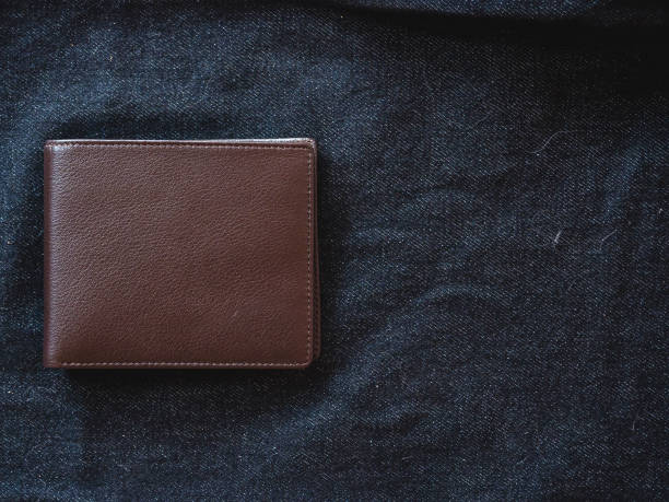 istock Brown leather wallet on jeans background. 1399867697
