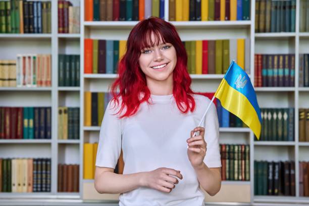 estudante adolescente com bandeira da ucrânia na biblioteca - teenage girls ideas blue yellow - fotografias e filmes do acervo