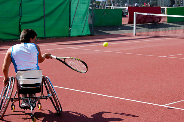 Wheelchair tennis player A wheelchair tennis player during a tennis championship match, taking a shot. wheelchair tennis stock pictures, royalty-free photos & images