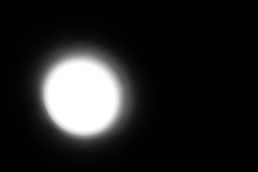 A white glowing lamp in the dark. White light in the dark. The light at the end of the tunnel. White on black. Black background and white spot. Sunlight. light from the moon.