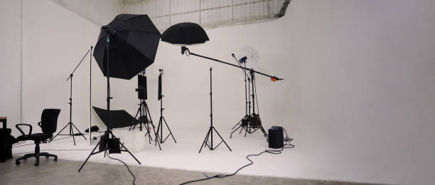 istock Studio video production lighting set. Behind the scenes shooting production set up by crew team camera and equipment in studio. Video production filming or commercial movie film live streaming online. 1399874458