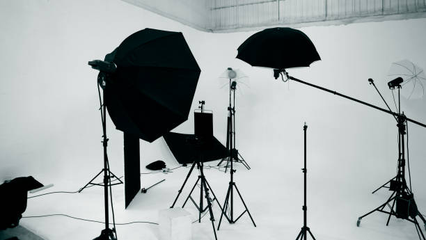 istock Studio video production lighting set. Behind the scenes shooting production set up by crew team camera and equipment in studio. Video production filming or commercial movie film live streaming online. 1399874471