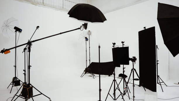 istock Studio video production lighting set. Behind the scenes shooting production set up by crew team camera and equipment in studio. Video production filming or commercial movie film live streaming online. 1399874475