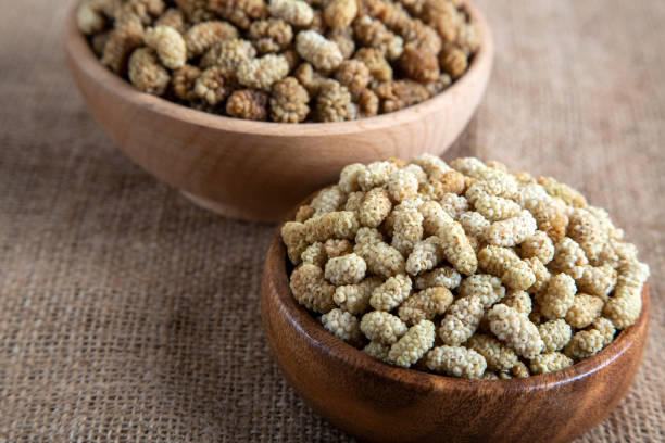 istock Bowl full of dried mulberry on a fabric background 1399875744