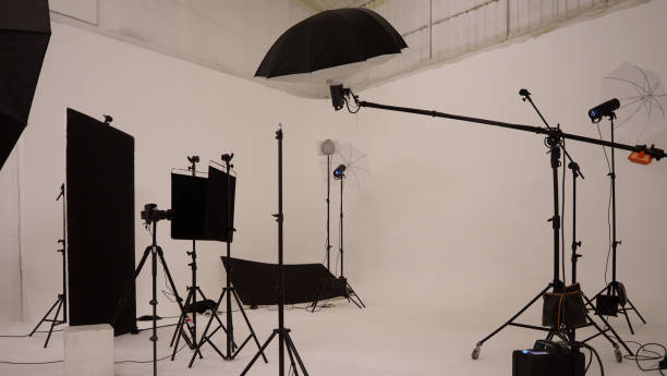 istock Studio video production lighting set. Behind the scenes shooting production set up by crew team camera and equipment in studio. Video production filming or commercial movie film live streaming online. 1399875958