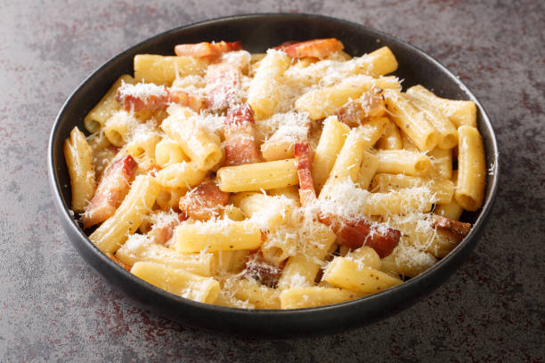 pasta italiana alla gricia en un plato con pecorino romano rallado y primer plano de guanciale. horizontal - pancetta fotografías e imágenes de stock