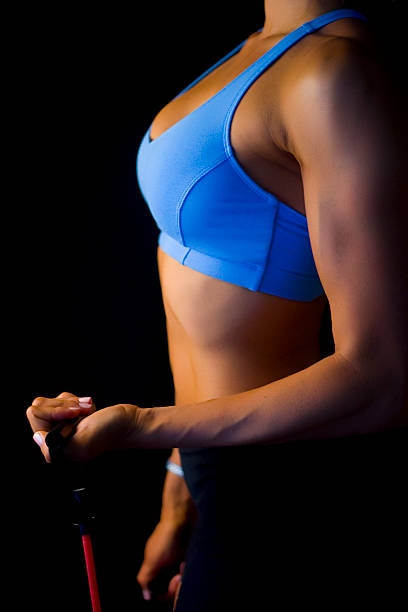 Faceless upper torso female doing bicep curl stock photo