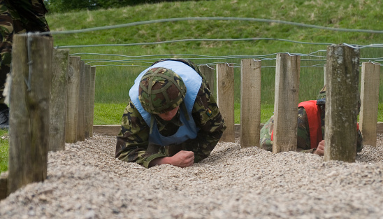 UK soldier crawls under wire on an assault course