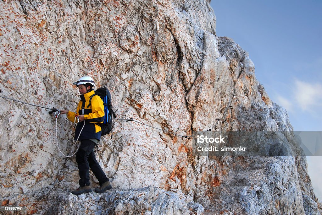 Mujer es ascendente mediante ferrata la montaña - Foto de stock de Accesorio de cabeza libre de derechos