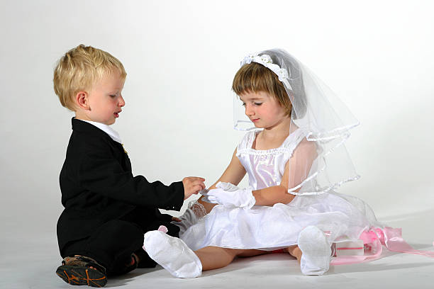 cute toddler boy and girl playing getting married and exchanging rings