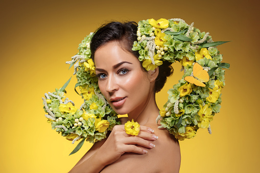 Studio portrait of a beautiful brunette Flower Queen wearing a unique headpiece