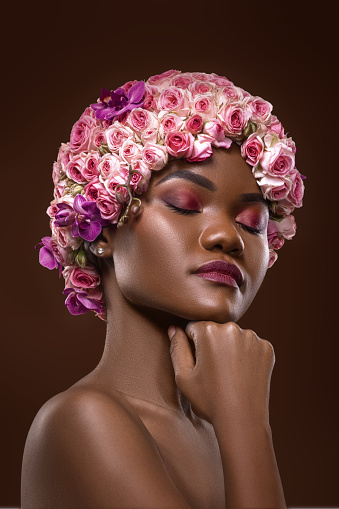 Studio portrait of a beautiful young African Flower Queen wearing a unique pink headpiece