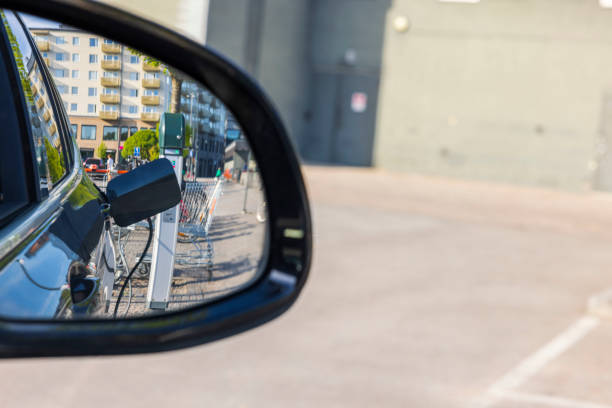 View in side mirror of electric car on connect charging cable. Sweden.