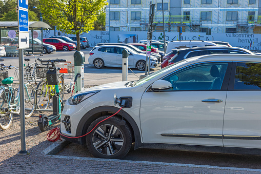 Sweden. Uppsala. 05.23.2022. Close up view of connected charging cable to Kia car from an electric vehicle charging station.