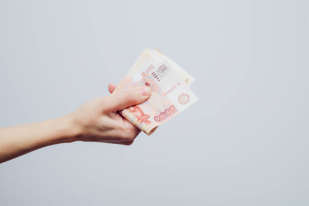 istock A hand holds a stack of five thousandth bill folded in half on a white background. Finance concept 1399888664