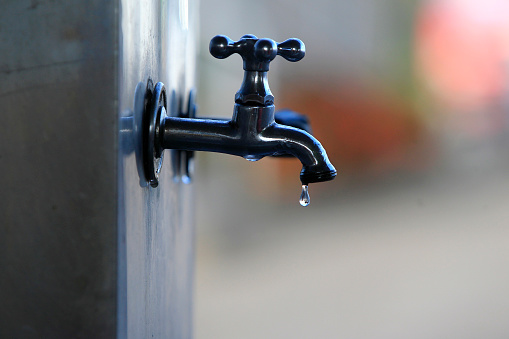 ilheus, bahia, brazil - may 22, 2022: water drop falling from a leaking faucet in the city of Ilheus.