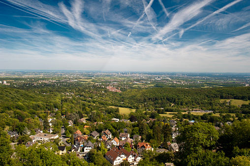 Dramatic cloudy sky with contrails over the Rhine-Main area with the skyline of Frankfurt am Main on the horizon and the Vordertaunus with the city of Kronberg in the foreground