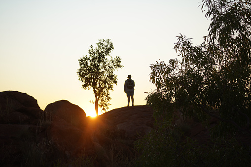 The silhouette of a person on rock at devils marbles in the Northern Territory
