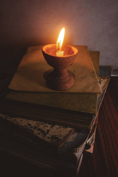 istock Old books by the burning candle 1399895012