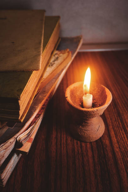 istock Old books by the burning candle 1399895031