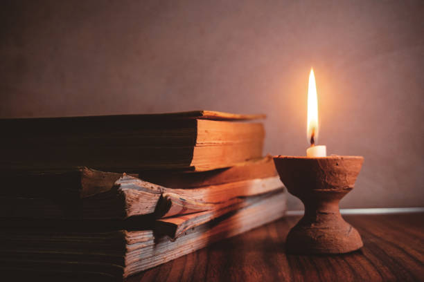istock Old books by the burning candle 1399895990