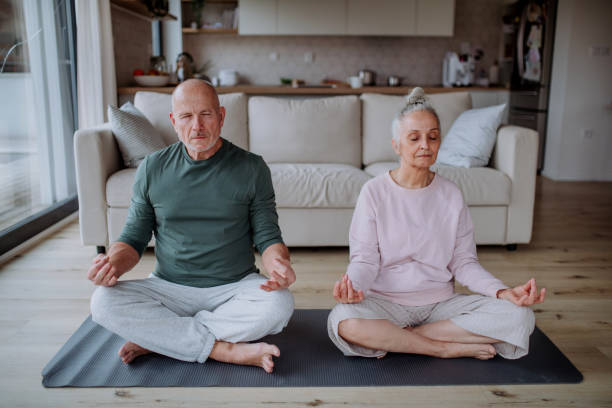 istock Senior couple doing relaxation exercise together at home. 1399896197