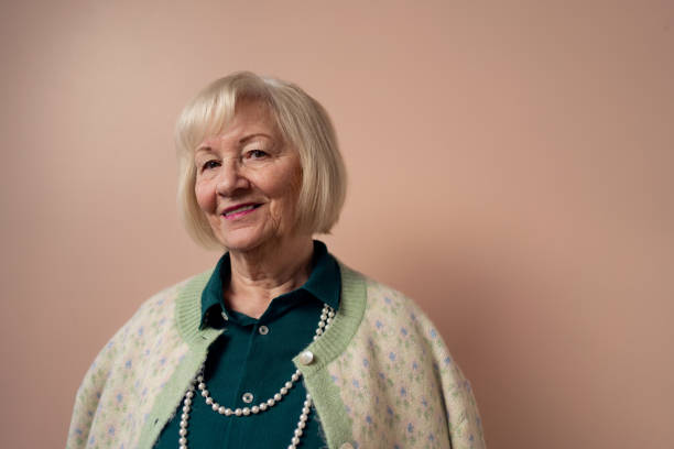 istock Smiling elegant elderly woman on pink color background, studio portrait 1399896942