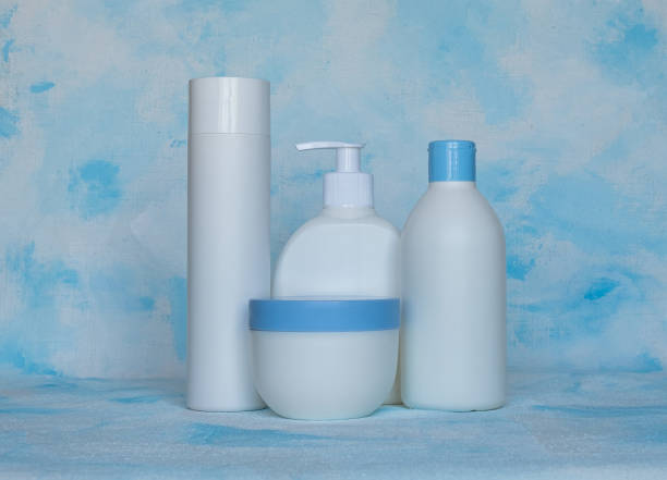 bottles for cosmetic products without a label. facial skin care concept. texture background - liquid soap blue plastic textile imagens e fotografias de stock