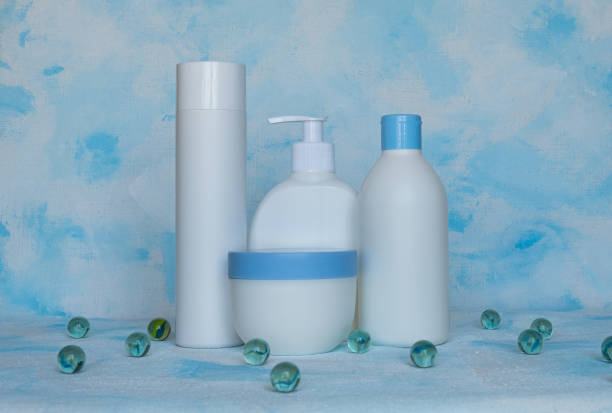 botellas para productos cosméticos sin etiqueta. concepto de cuidado de la piel facial. textura de fondo. bolas de vidrio - liquid soap blue plastic textile fotografías e imágenes de stock