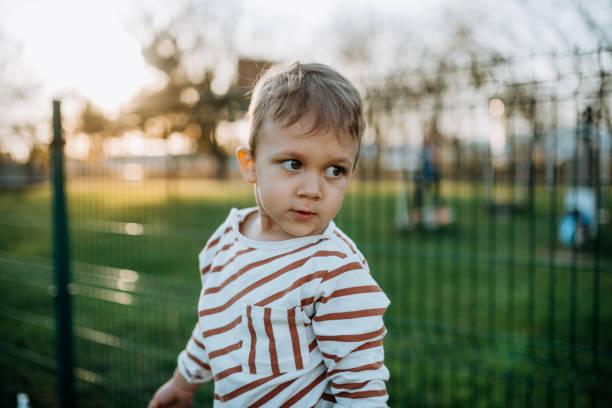 istock Little boy looking away outside in park 1399900169