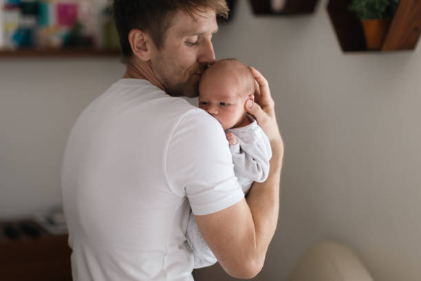 istock Father holding his newborn son at home. 1399905229