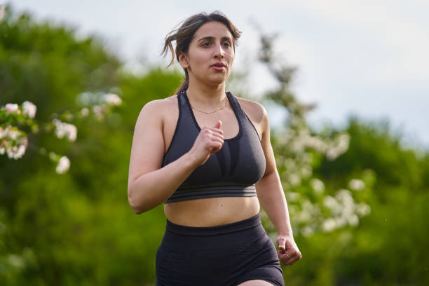 istock Plus size lady running through an orchard 1399905645