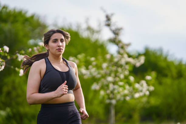 istock Plus size lady running through an orchard 1399905647