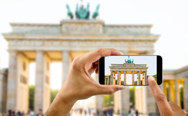 taking a photo of a brandenburg gate in berlin tourist taking a picture with your mobile phone brandenburg gate central berlin photos stock pictures, royalty-free photos & images