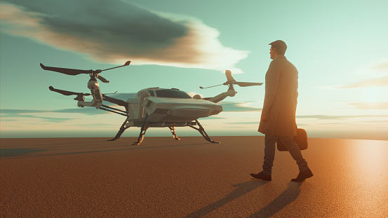Man walks up to a eVTOL, an electric helicopter which can operate automatically. The man wears business clothes and holds on to a briefcase.