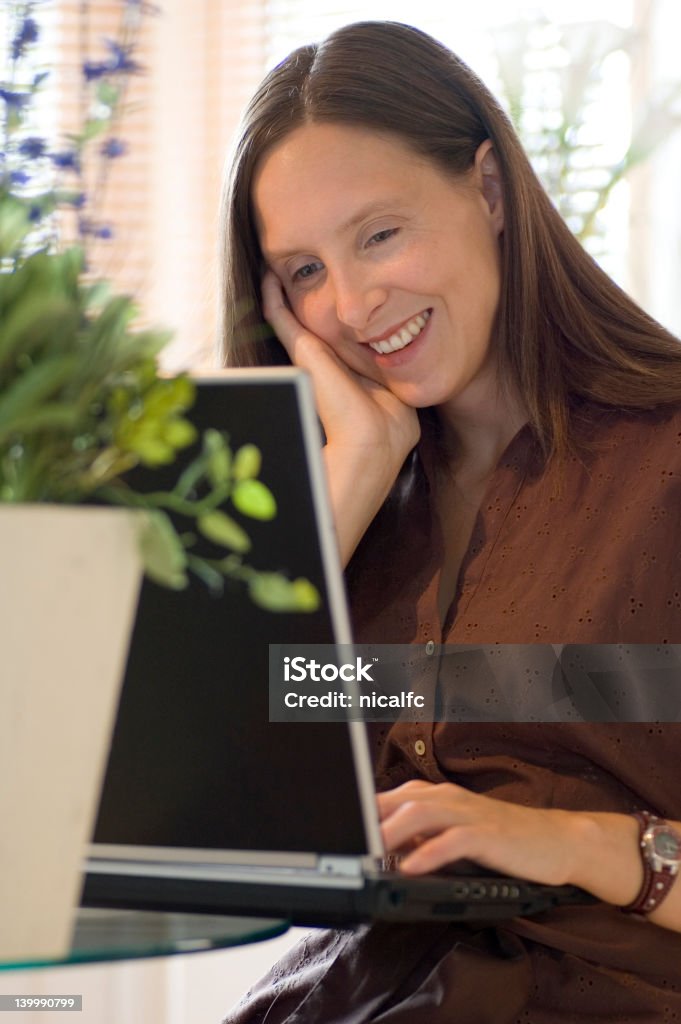 Linda mulher trabalhando em um laptop - Foto de stock de Aconchegante royalty-free