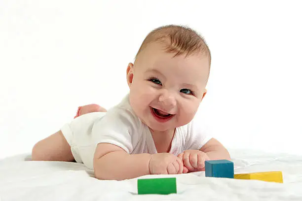 Photo of Baby have tummy time and playing with blocks 