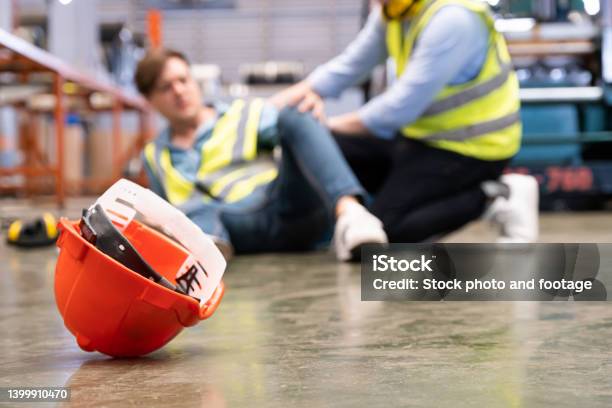 Selective Focus At Hat Men Worker Feel Painful And Hurt From The Accident That Happen Inside Of Industrial Factory While His Coworker Come To Give Emergency Assistance And Help Accident In Factory Stock Photo - Download Image Now