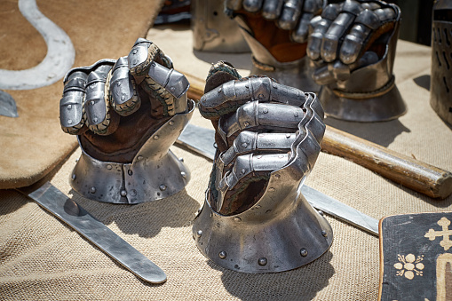 Closeup of steel vintage knight gloves. Against the background of other uniforms of the Middle Ages.