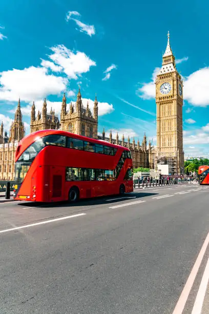Double-deck red bus on Westminster Bridge with Big Ben and Houses of Parliament on the background in London, UK