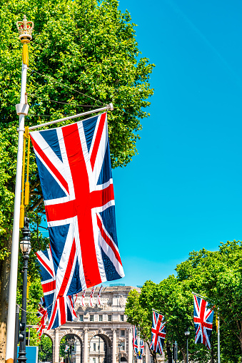 Flying and waving flag of Dominican Republic on wind on blue sky background