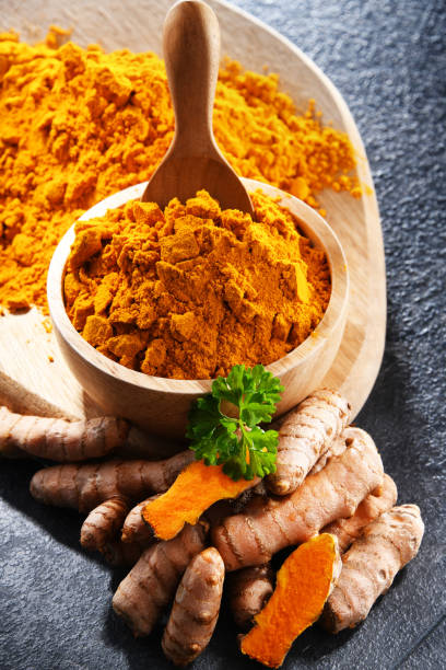 istock Composition with a bowl of ground turmeric and its fresh rhizome 1399921645