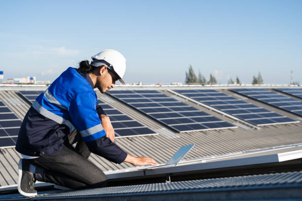istock Asian technician installing inspection or repair solar cell panels on background field of photovoltaic solar panels solar cells on roof top factory. 1399922730