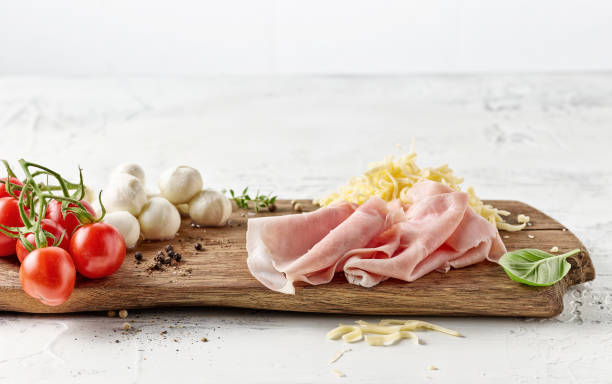 various pizza ingredients various pizza ingredients on rustic wooden cutting board shredded mozzarella stock pictures, royalty-free photos & images