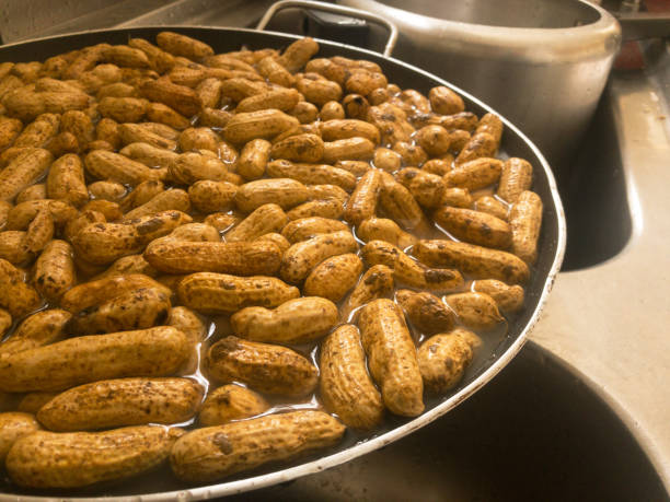 mesa de festa de junho comida típica brasileira de junho. escrito em português (amendoim cozido). amendoins cozidos. comida típica da festa junina ou são joão. fundo de amendoim. amendoim na panela - boiled - fotografias e filmes do acervo